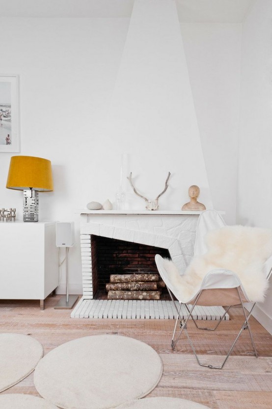white faux fur covers and rugs, antlers, pebbles and firewood make this space Nordic yet fall-like