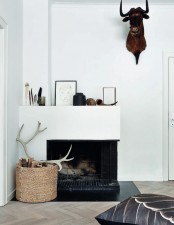 a basket with firewood and antlers plus a faux animal head on the wall for simple and modern fall decor