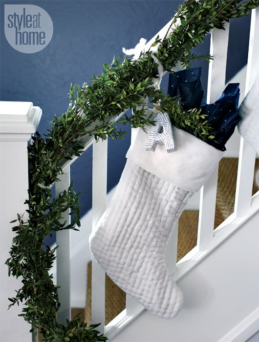 Evergreen garland combined with simple white monogrammed stockings is a very effective way to decorate a staircase in a minimalist style.