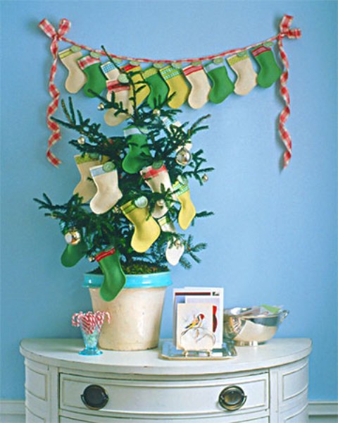 a colorful stocking garland plus a mini potted Christmas tree decorated with matching stockings is a cool idea for a bright and colorful holiday space