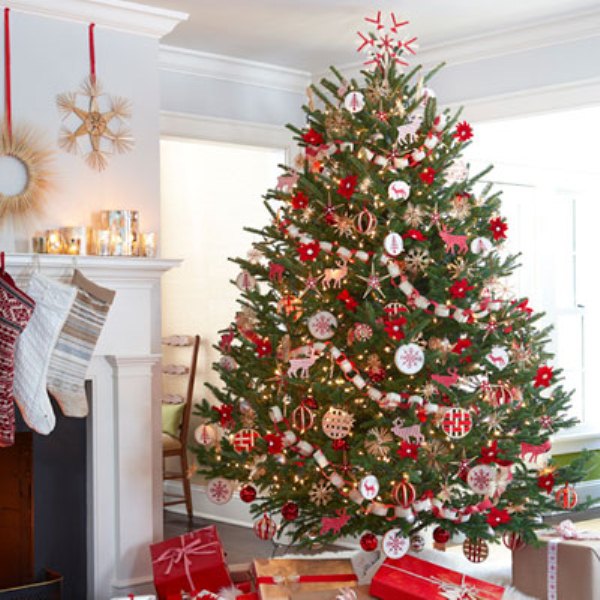 A bold traditional Christmas tree in red and white, with garlands, embroidery hoop and usual ornaments is very Scandi like