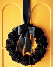 a black fabric flower wreath with a black ribbon bow is a stylish and elegant Halloween decor idea