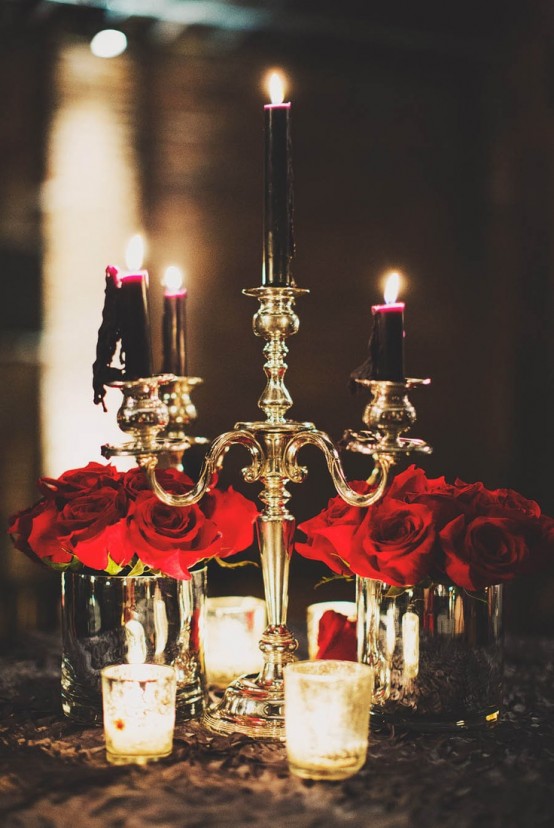 red roses pair up beautifully with deep purple and black candles in a gold candelabra for a Halloween decoration