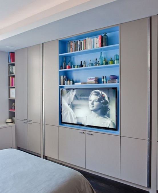 a whole wall taken by wardrobes, with built-in shelves and a TV is a smart idea for a small bedroom, here you may store a lot of things