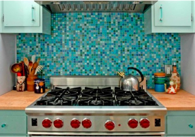 A light blue and mint kitchen with light stained countertops, a bold turquoise and blue tile backsplash that matches the kitchen colors