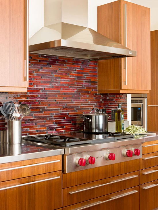 A light stained kitchen with a bold rust, burgundy and deep red mosaic tile backsplash looks very retro like and very bold