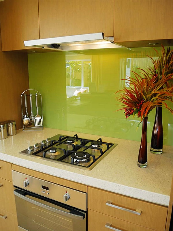 A light stained kitchen with modern handles, with a super bold neon green glass backsplash is a colorful and bold idea
