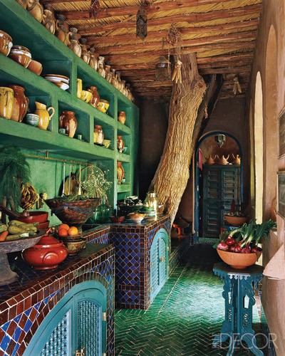 a bright vintage kitchen in green, with bold tile clad cabinets, a green tile floor and Moroccan decor is super bold