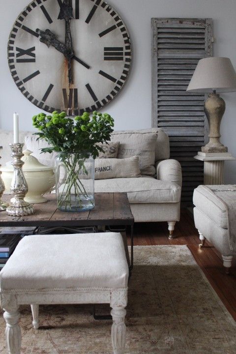 Large vintage wall clock with rust on them mixed with neutral furniture is a great way to make a farmhouse living room looks really interesting.
