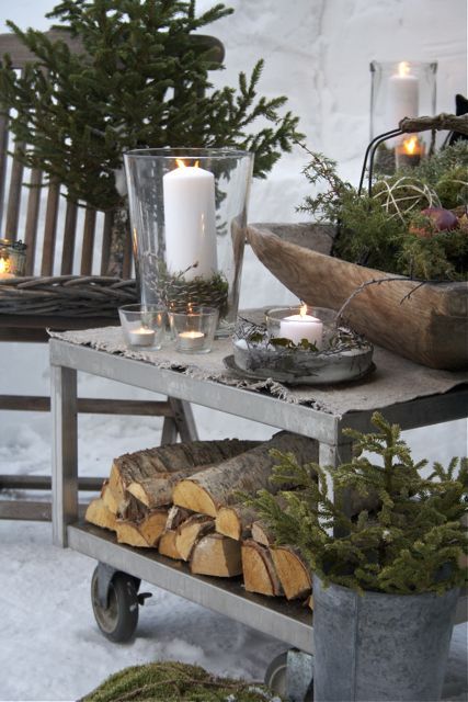 Nordic Christmas decor with firewood, fir branches, moss, candles is a great idea for a rustic and all natural feel in your outdoor spaces