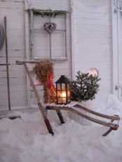 a rustic decoration – a lounger with dried herbs, a lantern, fir branches in a pot and a window frame with a vine heart for your backyard or front one