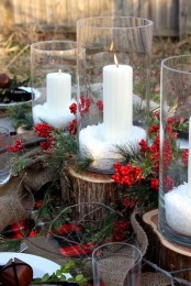 tree stumps with fir branches and berries plus candles in tall glasses will make your space feel rustic, whether it’s outdoor or indoor