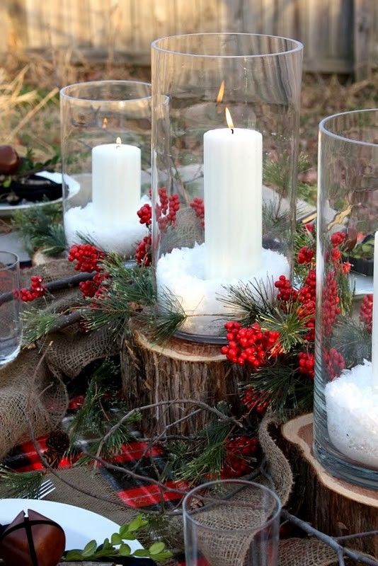 tree stumps with fir branches and berries plus candles in tall glasses will make your space feel rustic, whether it's outdoor or indoor