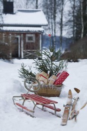 a red sleigh, skis, a basket with a Christmas tree and gifts for a cozy rustic feel in the space