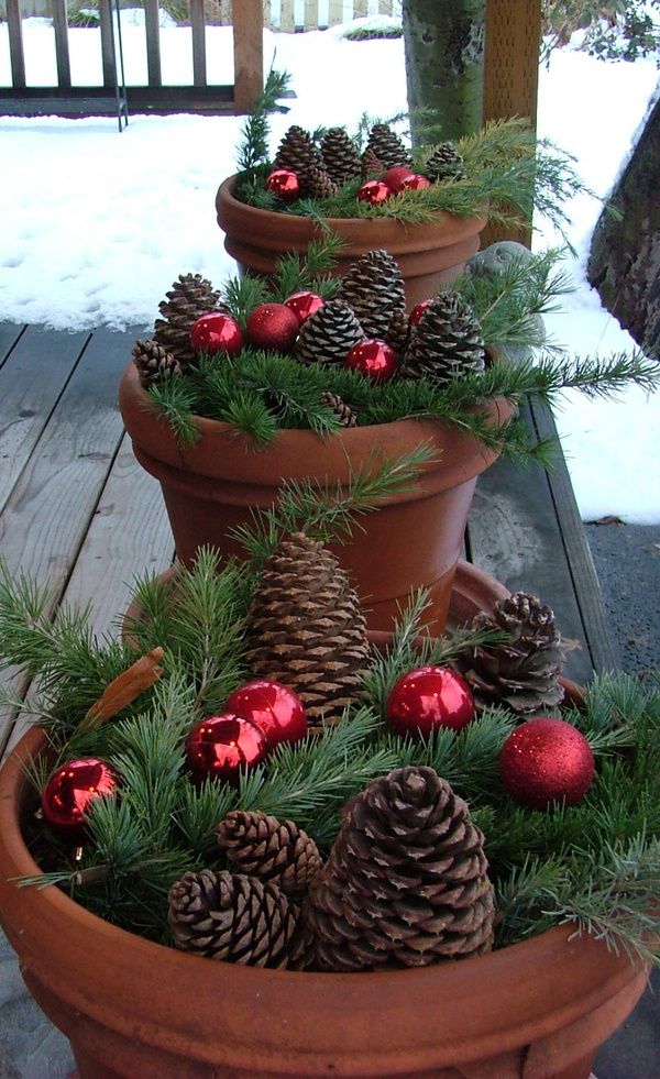 Terracotta pots with fir branches, pinecones and red ornaments will make your front porch amazingly rustic and very chic