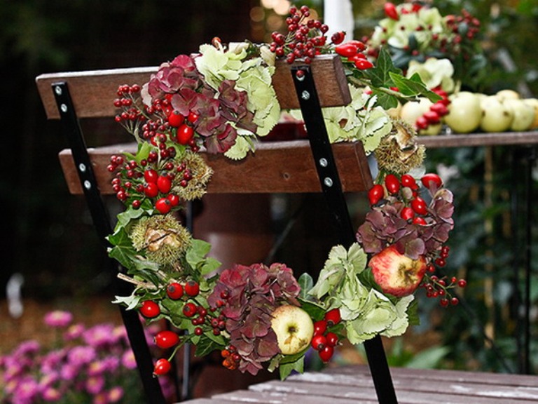 A fall or Thanksgiving wreath of greenery, berries, apples and dark blooms is a chic and very holiday embracing idea