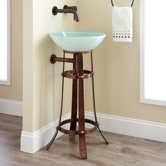 a darkened metal leg vanity for holding a blue glass bowl sink is a very bold and unusual idea for an eclectic bathroom