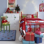 colorful Christmas bedding and a patchwork blanket, red decor, an advent calendar and bright gift boxes will make the kid’s room Christmassy