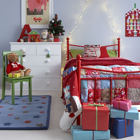 colorful Christmas bedding and a patchwork blanket, red decor, an advent calendar and bright gift boxes will make the kid's room Christmassy