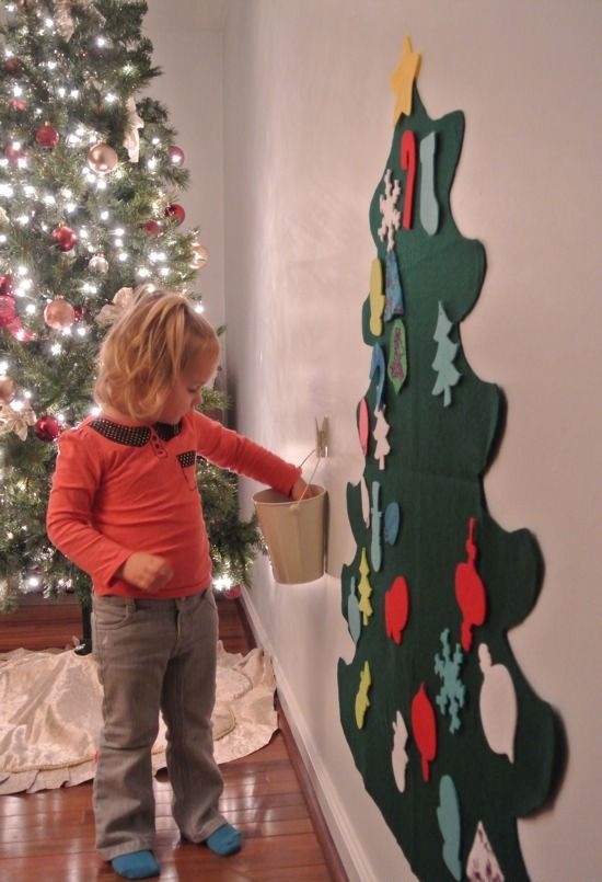 A felt wall mounted Christmas tree decorated with felt letters and numbers and other ornaments that you can make together with your kids