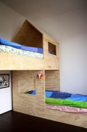 a small kids’ room with a plywood bunk bed placed at 90 degrees, with bright bedding is a cool space for kids
