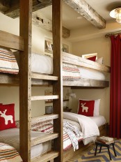 a welcoming kids’ room with stained built-in bunk beds, with a ladder and bright and neutral bedding, a rug and curtains