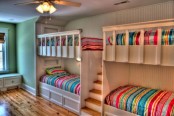 a neutral kids’ room with a green accent wall, white built-in bunk beds and bright bedding is amazing for kids