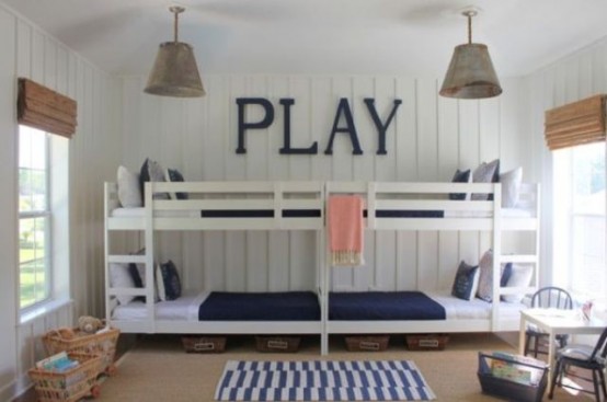 a neutral kids' room with beadboard walls, four white bunk beds, navy and white bedding, metal pendant lamps and woven lampshades