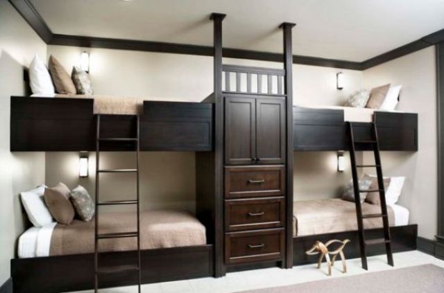 A stylish kids' room with white walls, dark stained built in bunk beds with matching ladders and neutral bedding is cool