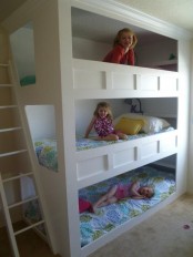 a small neutral kids’ bedroom with a bunk bed and printed bedding and a ladder can accommodate up to three kids
