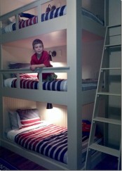 a white kids’ room with a bunk bed and colorful bedding, sconces and a ladder is a stylish idea