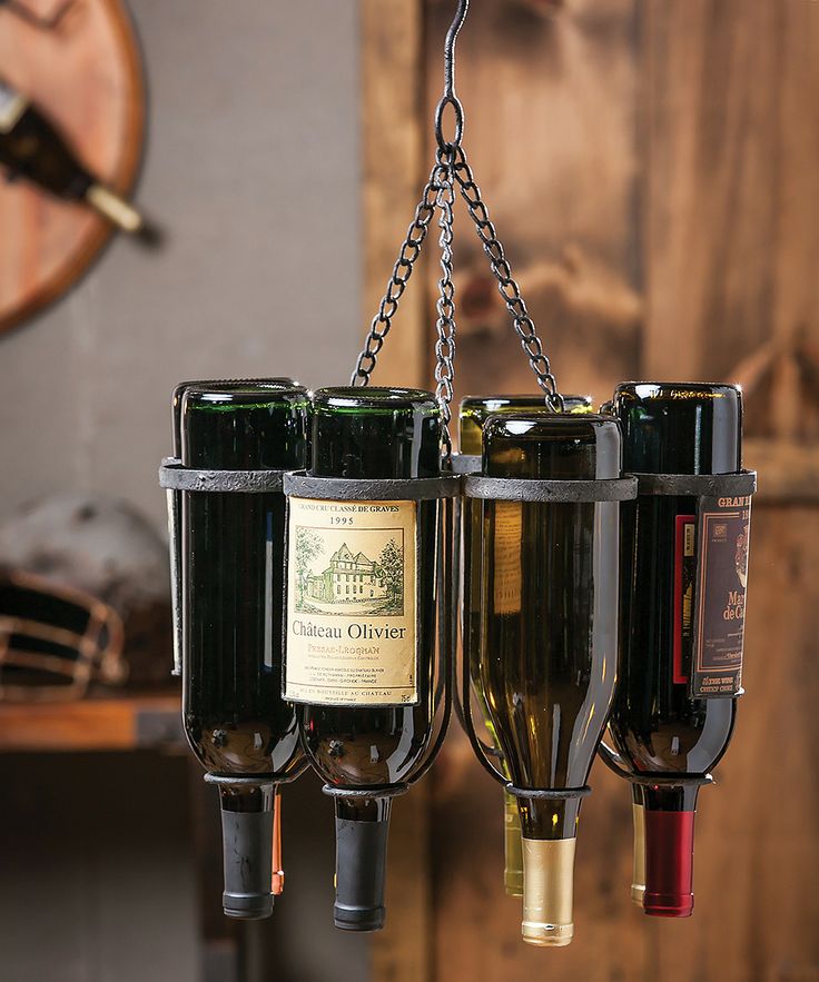 A metal hanger that holds bottles is a non traditional and bold solution that doesn't take floor space