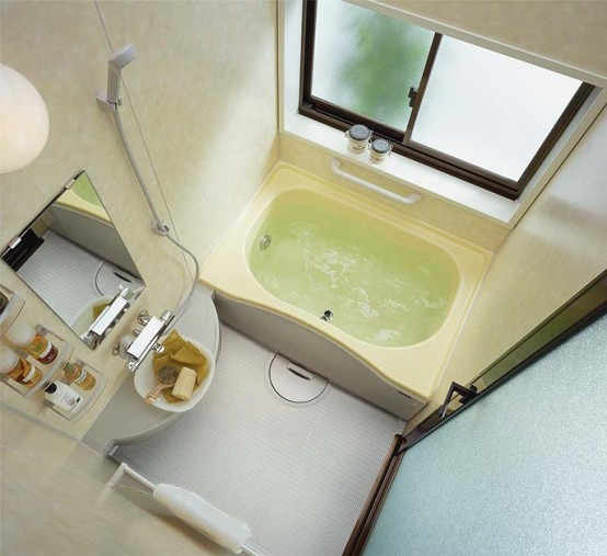 A tiny bathroom with a built in bathtub, a tiny floating vanity with a built in sink and a mirror