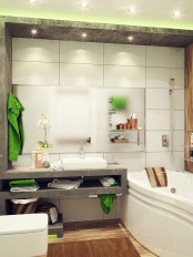 a bright contemporary bathroom done with white tiles and concrete, a wood tile floor, a tub and built-in lights