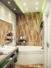 a contemporary bathroom done with wood like tiles, concrete, a sculptural bathtub and built-in lights