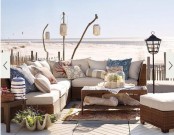 a truly beach patio with wicker furniture, neutral textiles and pillows, potted greenery and succulents and branches with paper lamps plus a gorgeous sea view