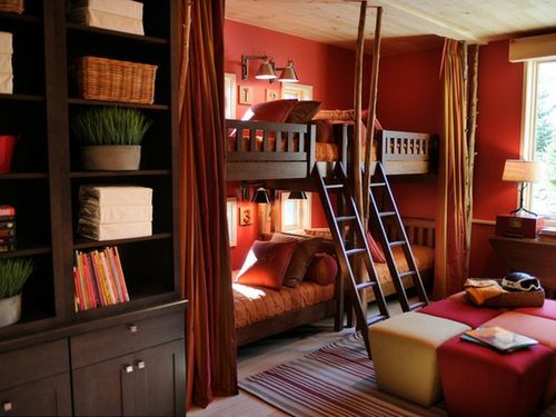 Traditional shared bedroom painted in a bold shade of red. Bunk beds for four kids could be hidden behind curtains for privacy.