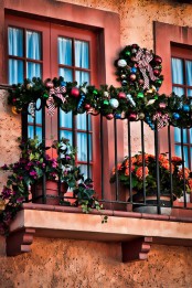 bold blooms in pots and ornaments and greenery garlands and wreaths to decorate the balcony for winter holidays