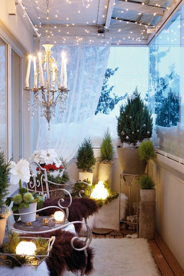 A cozy winter balcony done with mini Christmas trees, lots of faux fur, a crystal chandelier and lots of lights