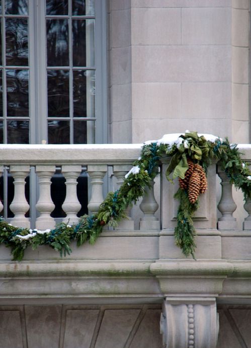Greenery garlands with pinecones will make your balcony look more festive and holiday ready