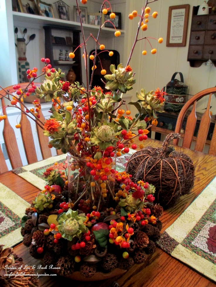 A traditional fall centerpiece with berries, pinecones, branches, vine pumpkins, succulents and veggies is a cool idea for the fall