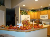 a bright faux fall leaf arrangement with pumpkins for decorating a fall kitchen – a durable and simple idea