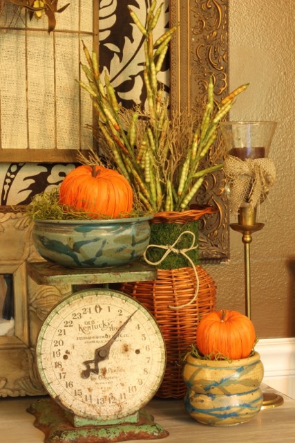 bright faux pumpkins, branches and wheat for giving a rustic and vintage fall touch to the kitchen