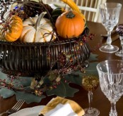 a fall centerpiece of a bowl filled with fake fruits and vegetables, with berries and twigs will last as long as you’ll want