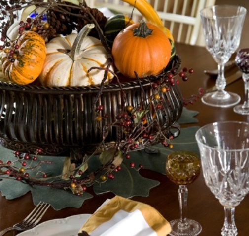 a fall centerpiece of a bowl filled with fake fruits and vegetables, with berries and twigs will last as long as you'll want