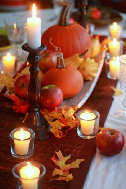 a wooden tray with natural pumpkins, gourds and apples plus leaves and candles around for a cute and easy fall centerpiece