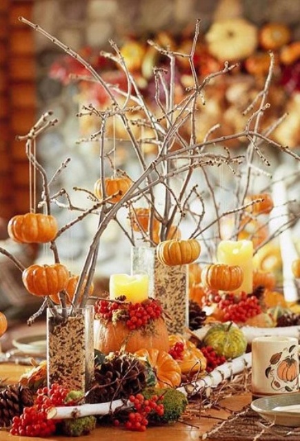 a colorful fall tablescape with faux pumpkins, pinecones, branches and berries feels very woodland-like