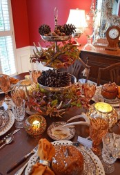 a bold traditional fall table with antlers, fall leaves, pinecones, colorful glasses and mercury glass candleholders