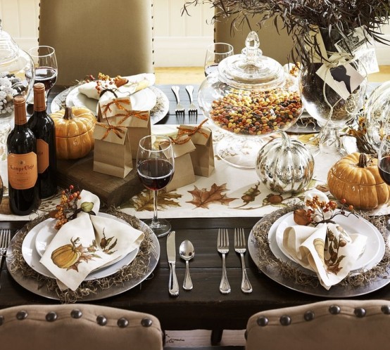 a neutral fall tablescape  with fall printed napkins and a table runner, pumpkin bowls and a greenery arrangement