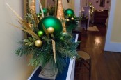 a cool green and gold Christmas decoration in an urn, with ornaments, twigs and branches is a beautiful idea for the holidays